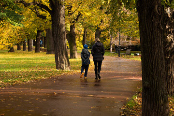 Obraz premium Mother and son are walking and talking on Letna Park in Autumn 2020 on Prague 6, during quarantine period due to outbreak of COVID-19 as winter is starting, Czech Republic