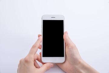 female hands holding new modern black smartphone isolated on white background, close view . High quality photo