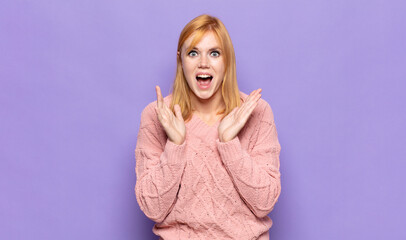 red head pretty woman feeling shocked and excited, laughing, amazed and happy because of an...