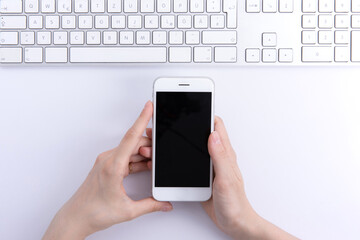 female hands holding new modern black smartphone isolated on white background, close view . High quality photo