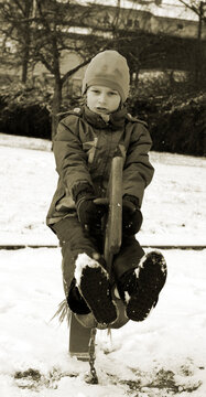 Black and white picture child on the rocking horse in the snow