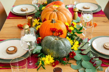 Beautiful table setting with pumpkins in dining room