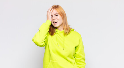 red head pretty woman laughing and slapping forehead like saying d’oh! I forgot or that was a...