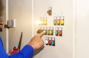 Hand of people key switch select mode in electrical control panel contains switch buttons for...