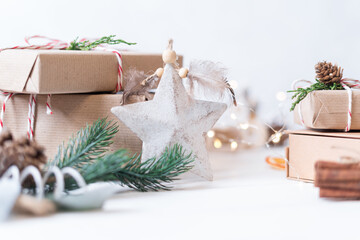  Merry Christmas and Happy New Year on white background. Holidays greeting card. Christmas lights and decoration with wrapping gifts. Selective focus.