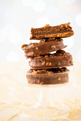 Chocolate biscuit sandwich in chocolate and nut glaze on christmas background