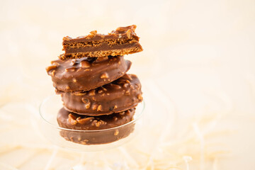 Chocolate biscuit sandwich in chocolate and nut glaze on christmas background