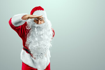 Fototapeta na wymiar Portrait of a cheerful Santa Claus in a red suit close-up, light background. Concept for christmas eve, vacation, holiday banner, new year.