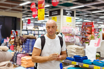 A man during a sale chooses towels