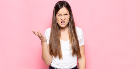 young pretty woman looking angry, annoyed and frustrated screaming wtf or what’s wrong with you