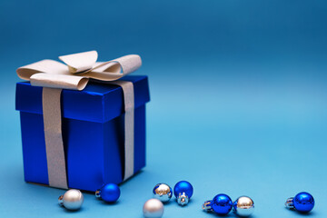 blue gift box with christmas balls on blue background