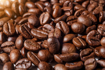 Freshly roasted coffee beans background.Dark roasted coffee beans with scoop on wooden background.