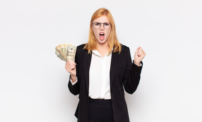 pretty woman  shouting aggressively with an angry expression or with fists clenched celebrating...