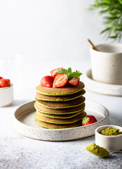 Matcha pancakes in a ceramic plate on a white background