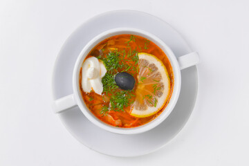Ukrainian beetroot soup - borscht with sour cream served in a white bowl over white background.
