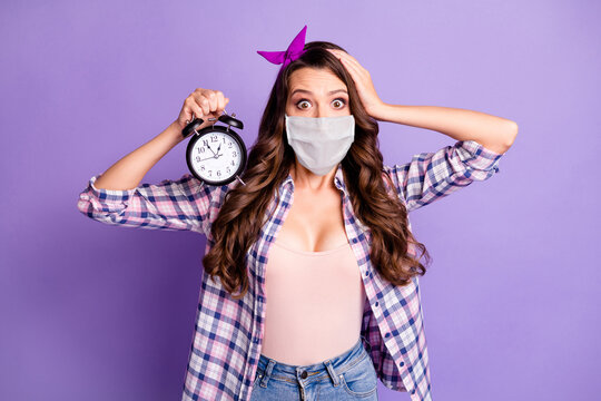 Photo of scared lady hold alarm clock wear flu cold mask checkered shirt headband isolated purple color background