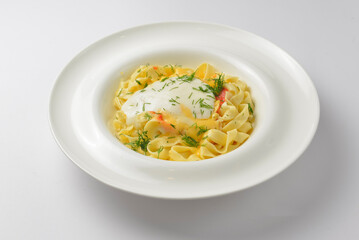 Delicious vegetarian dish of pasta with cheese served in a white plate over white background.