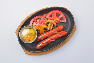 Grilled barbecue sausages and mushrooms in the pan with mustard dip sauce. Fast food concept.