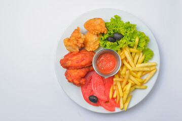 Buffalo chicken wings with tomato dip sauce. Served on a white plate over white background.