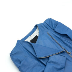 Fragment of a women's jacket made of blue genuine leather. Decorated with folds and stitching. Closure - zipper. White lining with dots. Isolated on white background. Bottom right corner.