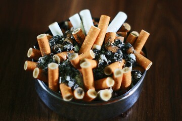 close up ashtray full of cigarettes butt