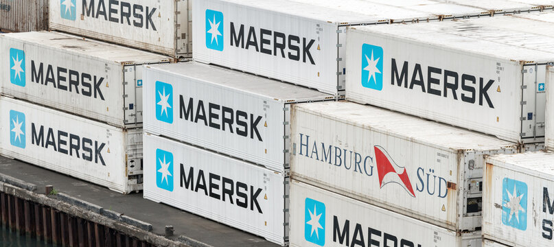 Large group of sea cargo freight containers Maersk and Hamburg Süd stacked on pier in container terminal warehouse commercial sea port in Pacific Ocean. Kamchatka Peninsula, Russia - August 27, 2019.