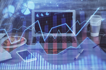 Double exposure of chart and financial info and work space with computer background. Concept of international online trading.