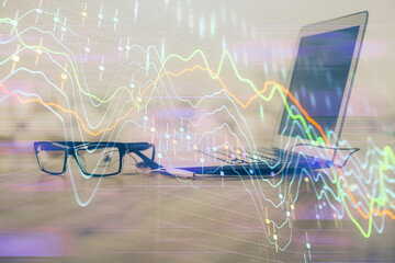 Stock market graph on background with desk and personal computer. Multi exposure. Concept of financial analysis.
