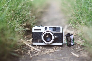 analog camera with 35mm canister film on the ground