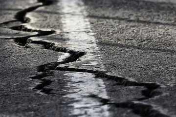 asphalt in cracks texture / abstract background cracks on asphalt road