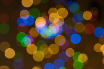 Abstract blurred background with colorful orange, blue green and red bokeh balls on a dark background