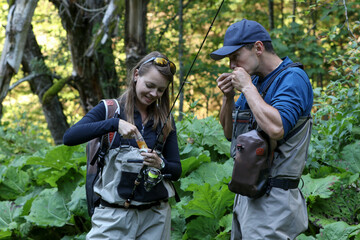 Young woman learning to fly fishing with a profesional guide
