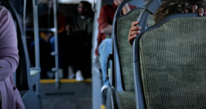 African-american little boy playing peek-a-boo inside public bus