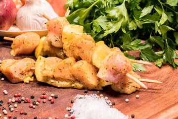 raw chicken skewers marinated with lemon on a wooden board