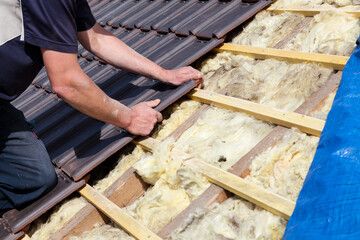 a roofer laying tile on the roof