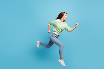 Fototapeta na wymiar Full length body size side profile photo of cheerful female student running fast hurrying up jumping high laughing isolated on bright blue color background