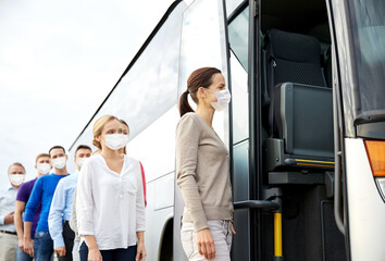 tourism and health concept - group of passengers wearing face protective medical masks for protection from virus disease boarding travel bus
