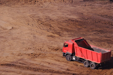 A red empty lorry stands on the sand View from above. Copy space for left and top text labeling