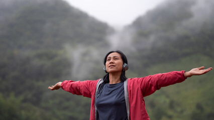 Fototapeta na wymiar Asia woman listening music on the mountain