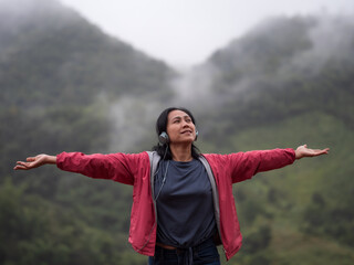 Asia woman listening music on the mountain