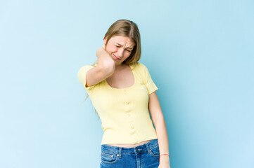 Young blonde woman isolated on blue background having a neck pain due to stress, massaging and touching it with hand.