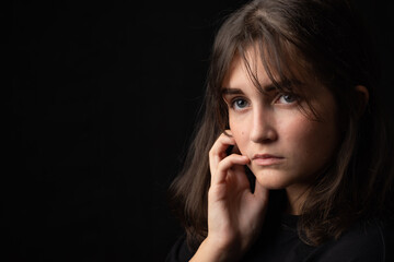 Psychological portrait of a beautiful young girl on a black background