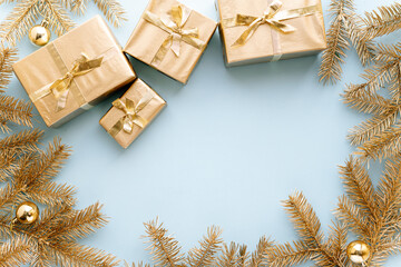 Blue Christmas or new year's background,plain composition of golden Christmas gifts and golden fir branches with christmas toys,Flatlay,empty space for greeting text.christmas concept.