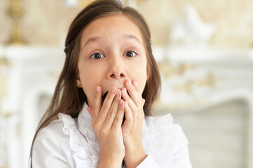 Close-up portrait of emotional little girl in white blouse