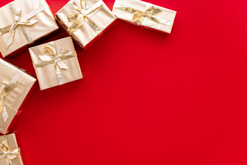 Red Christmas or new year's background, plain composition of golden Christmas gifts. Flatlay, empty space for greeting text.christmas concept.