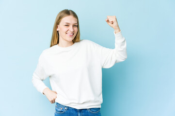 Fototapeta premium Young blonde woman isolated on blue background cheering carefree and excited. Victory concept.