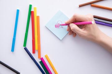 female hand writing with felt-tip pen over paper note on table, close view. High quality photo