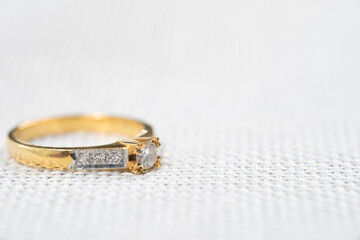 Minimal wedding diamond ring on white sack background.