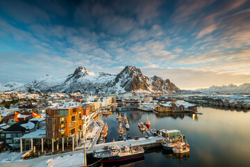 View over the port of Svolvaer on the Lofoten islands in colorful early morning sunrise in winter with snow