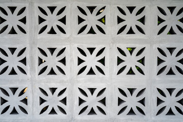 Flower fretwork brick pattern, perforated framework background, texture on white brick wall.